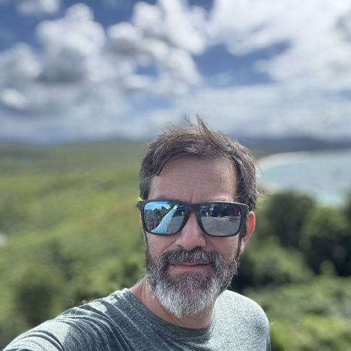 Tim, founder of Jonestopia, outdoors with green hills and the ocean behind